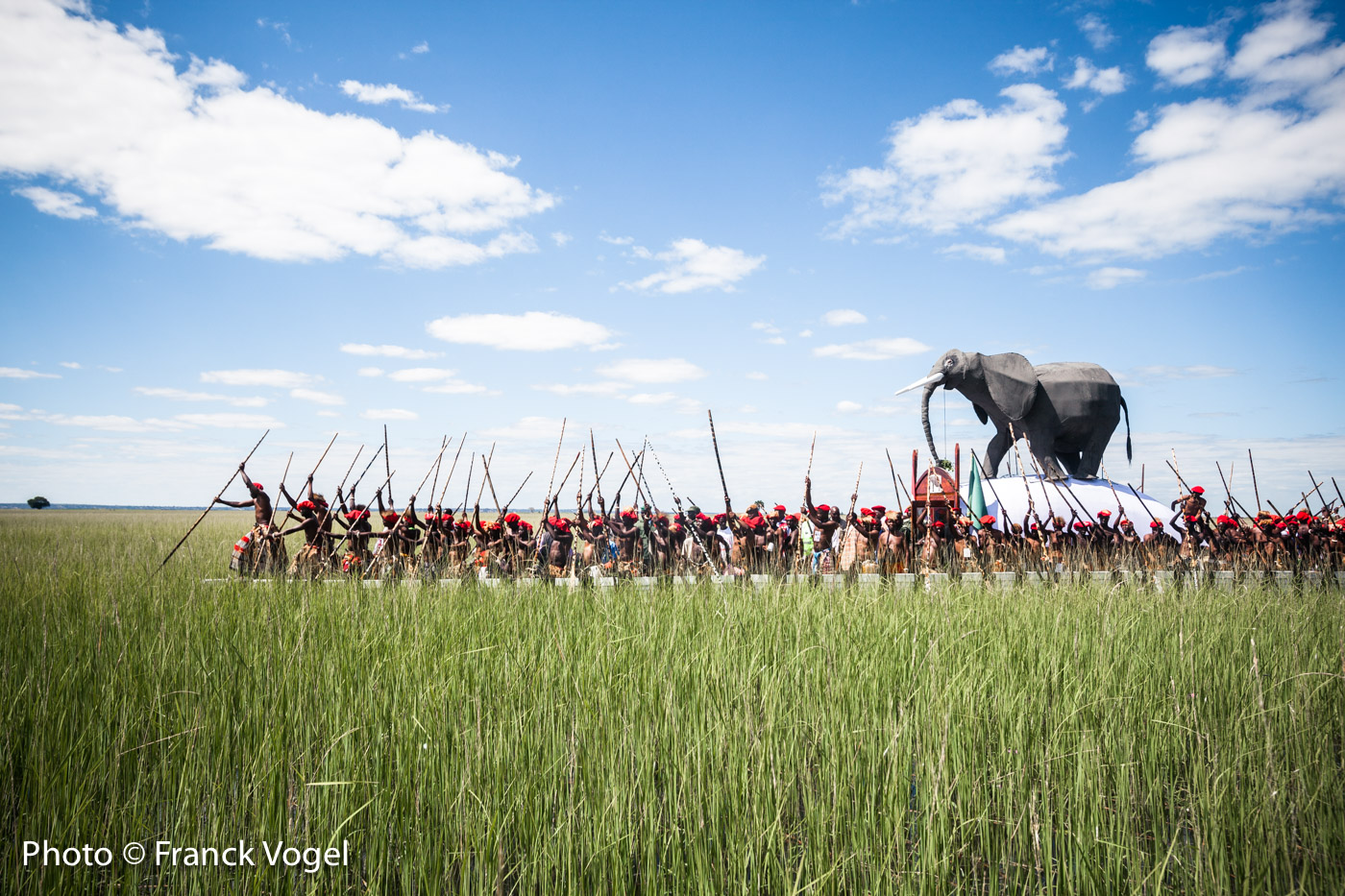 <p>Lealui, Barotseland, Zambia – The Barotseland and the amazing plains flooded by the Zambezi River in Western Zambia. In 2018, Lubosi Imwiko II, the King of the Barotse – also known as Lozi – has postponed the famous Kuomboka, the migration of the kingdom to dry land because for private reasons. It’s the first time it happened. April 28 he moved from Lealui (summer palace) to Limulunga (winter palace – April to June) using his Royal Barge topped with a 2m high elephant and propelled by 120 paddlers wearing leopard skins. During the 7h and 34km to reach the winter palace through the flooded plains, the drummers from the royal barge gives the rythm to all boats following, including the Queen’s barge (she passed away so her sisters and daughters are on it), the Ngambela (King’s prime minister), the royal Witchdoctor cannoe protecting the king and the royal barge with smoke and prayers, the cannoes with the gardians of former kings’ graves (dressed in white), and about 200 people with their cannoes. When approaching Limulunga there is a lot of excitment and people race with their cannoes – even 2 accidents – and sing. In the last kilometers an excited crowd of over 10,000 people welcomes the king in the sunset and the dust. A magical moment! In 2018, the chief guest wad Mwini Kalonga Gawa Undi, Chewa chief from the Eastern Province of Zambia.</p>
image Zambezi-Franck-Vogel-web-big-9